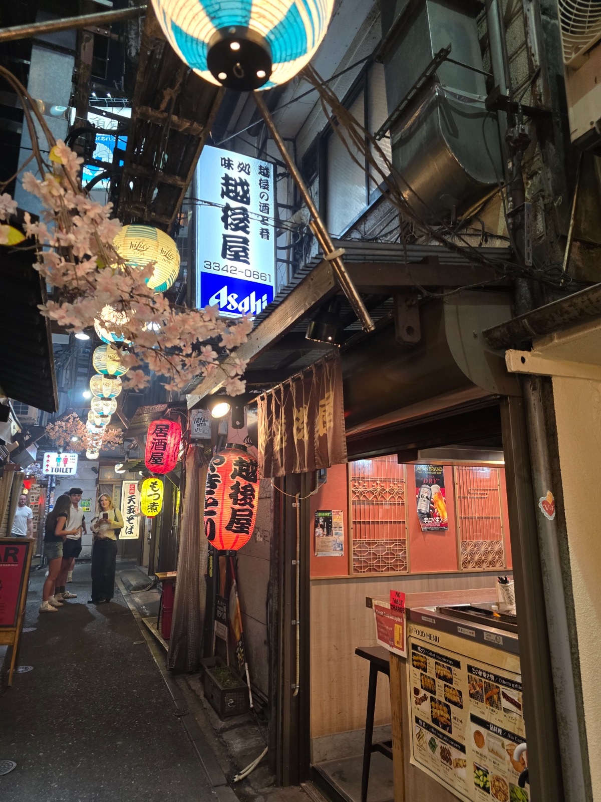Intimate counter seating, warm lantern light — Tokyo reference